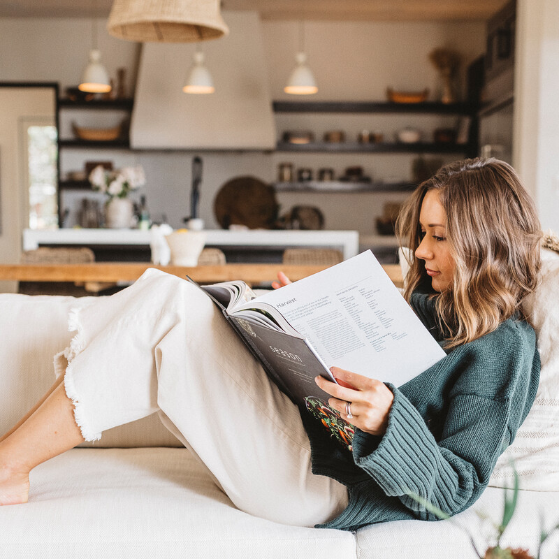 Camille Styles reading on couch.