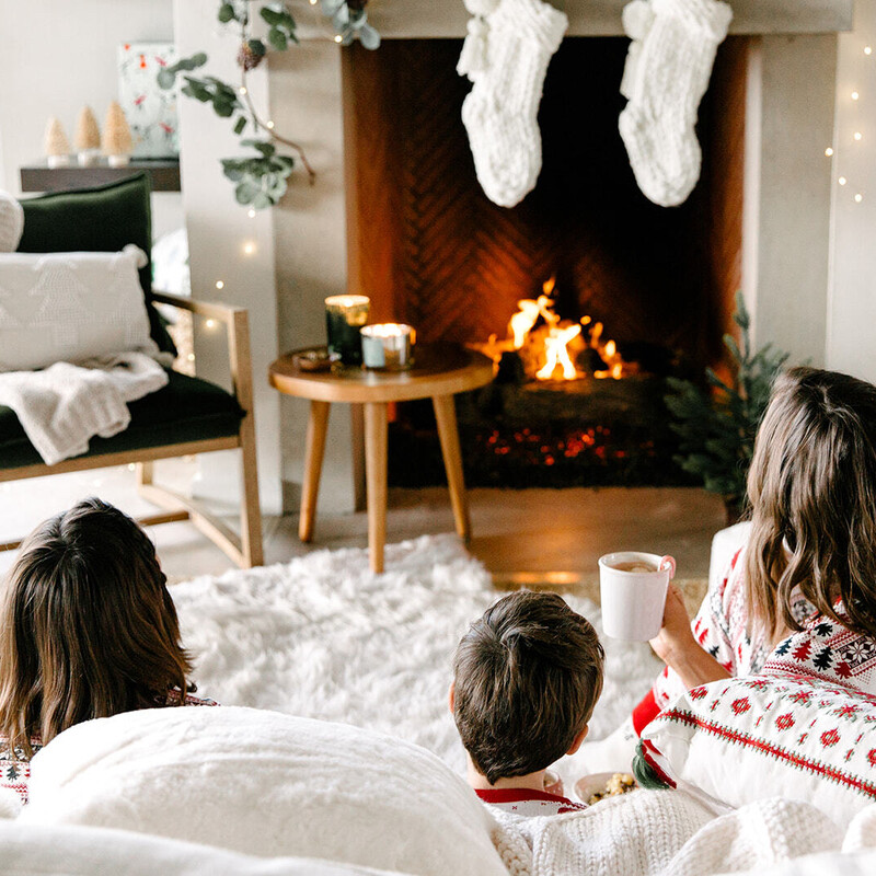 Family in front of the fire Christmas.