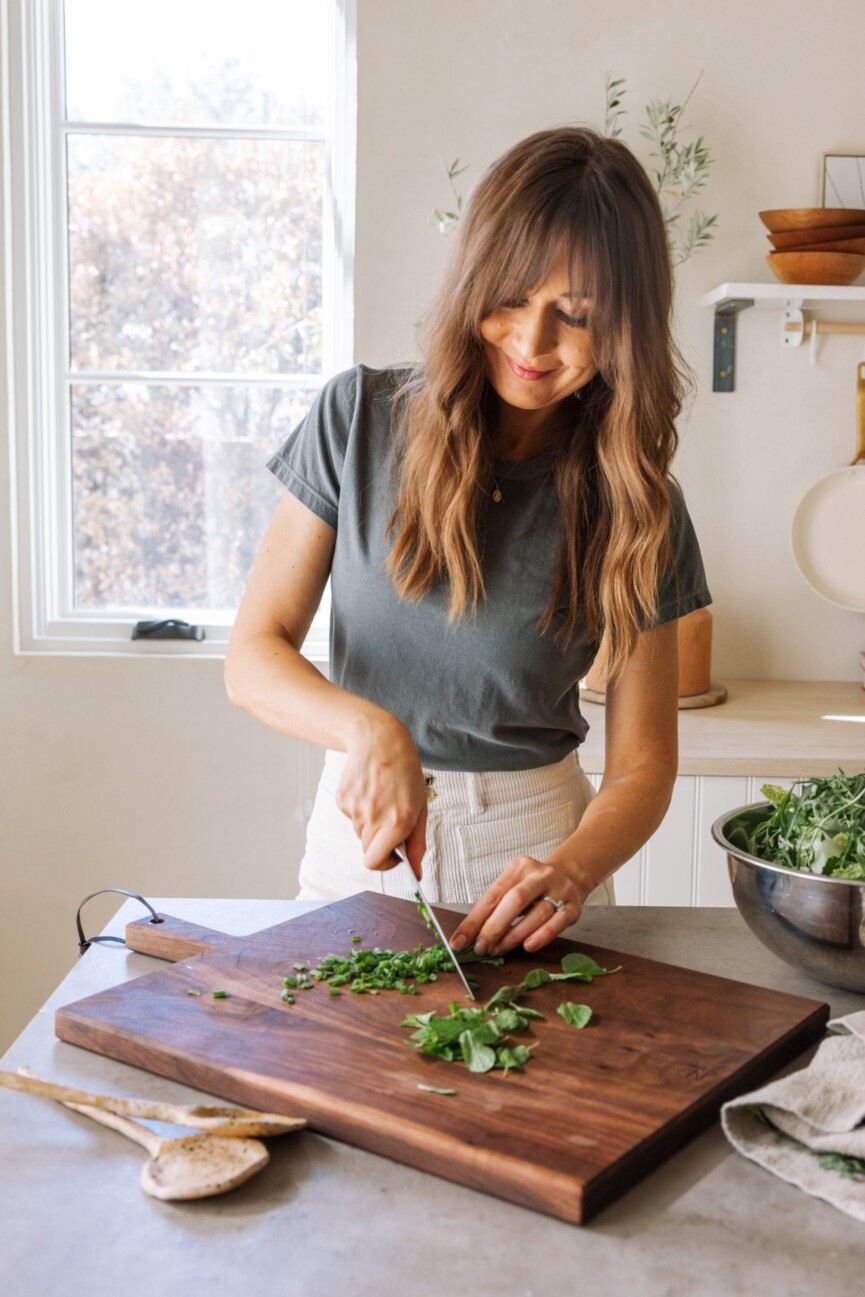 camille chopping herbs, fresh spring produce, greens, meal prep, kitchen, casa zuma gathering board_colostrum and gut health