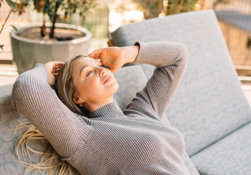 Iskra Lawrence laying outside on lounger chair in sun.