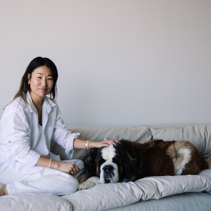 Jennie Yoon sitting on couch with her dog.