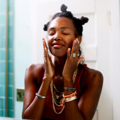 Woman doing skincare in mirror.