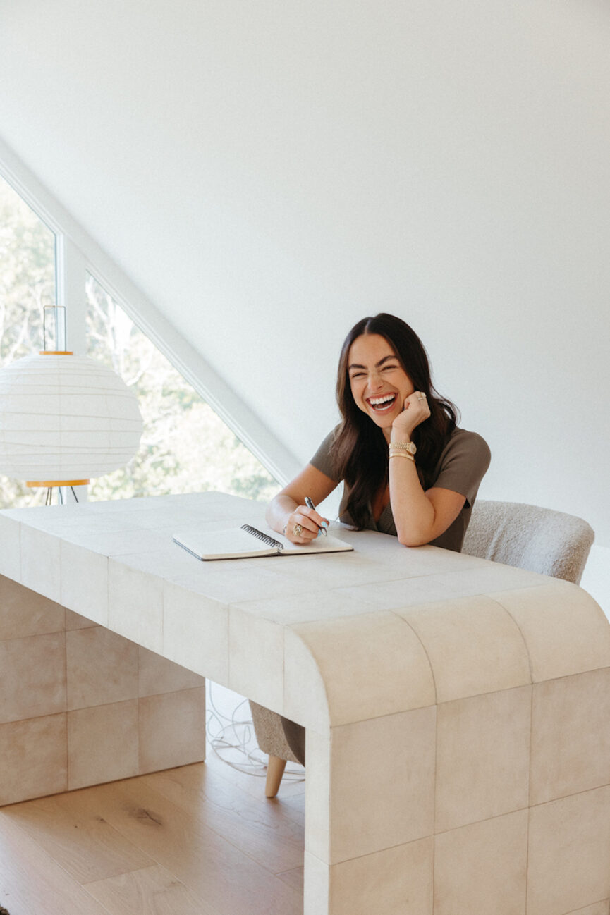 Woman working at desk in comfortable work from home clothes.